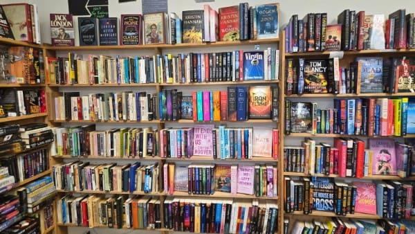 Wide front-of-store shelving wall filled with adult fiction, literary fiction, and bestsellers