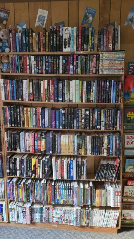 Packed shelves of children's adventure and fantasy books including popular series